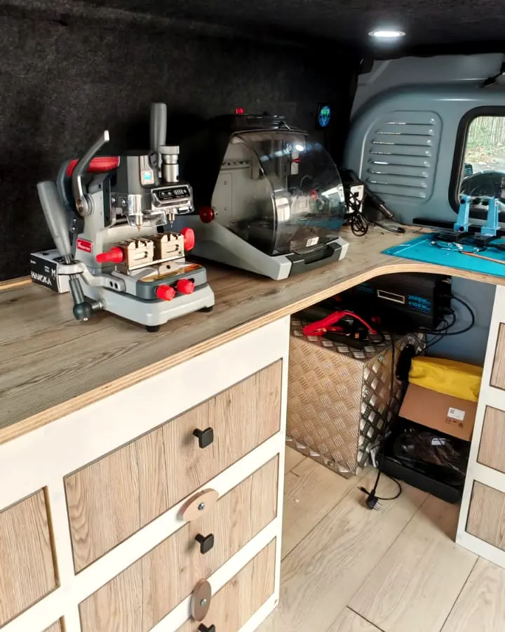 Machines de taille de clés posées sur l’établi, à l’intérieur du camion aménagé