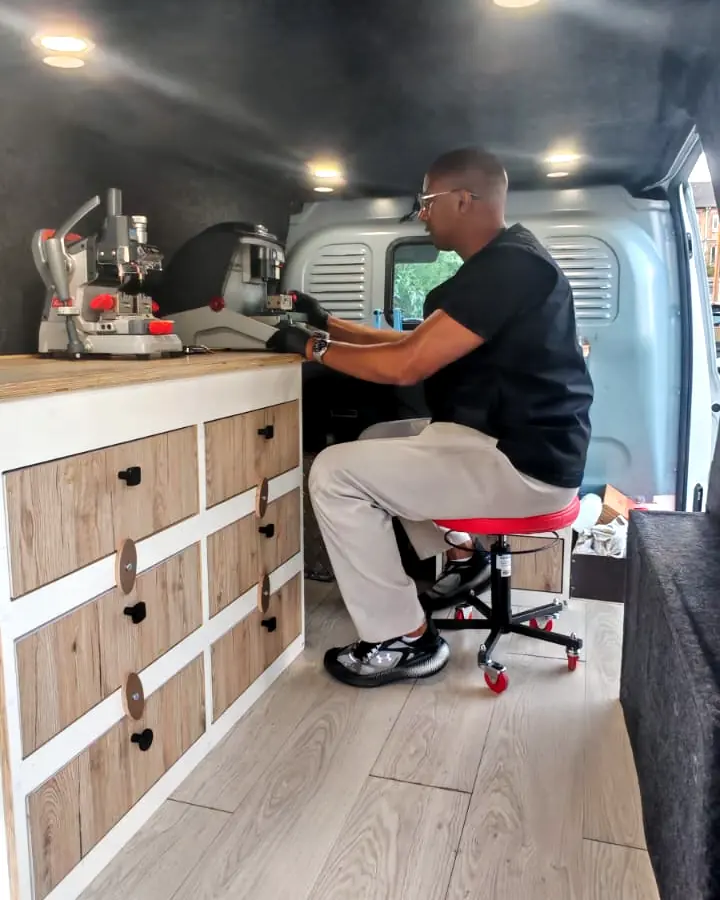 Yassine Macid taille une clé sur la machine, dans son camion aménagé